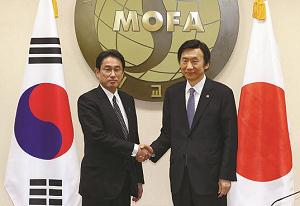 日韓の両外相が握手する写真