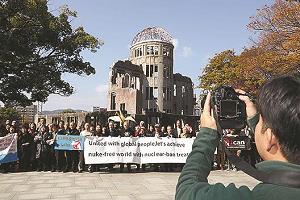 広島市の原爆ドーム前で被爆者や市民ら約80人が集まり、核兵器廃絶を世界に訴える動画を撮影している写真