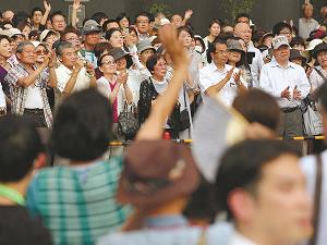 東京都議会選挙候補者の演説を聞く有権者の写真