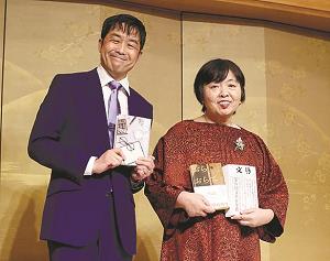 金屏風の前に立つ若竹千佐子さんと門井慶喜さんの写真