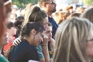 追悼集会で泣き崩れる高校生の写真