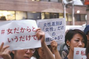 東京医科大の正門前で抗議の声を上げる人たちの写真