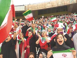 男子サッカーの試合を観戦しているイラン女性の写真