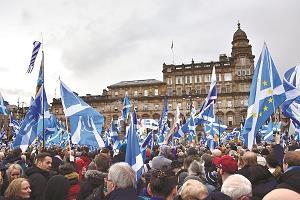 スコットランド独立をめざす集会に、青と白のスコットランド旗を持って集まった人たちの写真