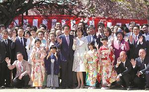 安倍晋三首相、昭恵夫人と記念撮影をする「桜を見る会」の参加者たちの写真