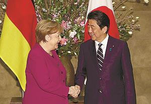 握手を交わすメルケル首相と安倍首相の写真
