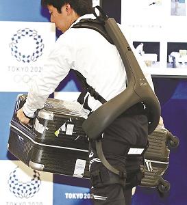 パワーアシストスーツを装着し荷物を運ぶ人の写真