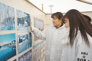 海辺に、震災前の様子を伝える写真が掲示されていて、ERINさんとSORAさんが解説している写真