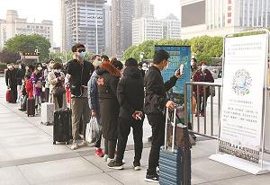 検温を受けて武漢市内の駅に入る人たちの写真