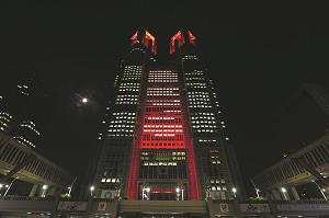 赤色にライトアップされた東京都庁の写真